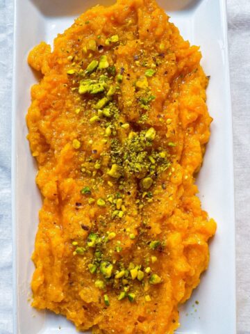 A plate of pumpkin halwa garnished with chopped pistachio